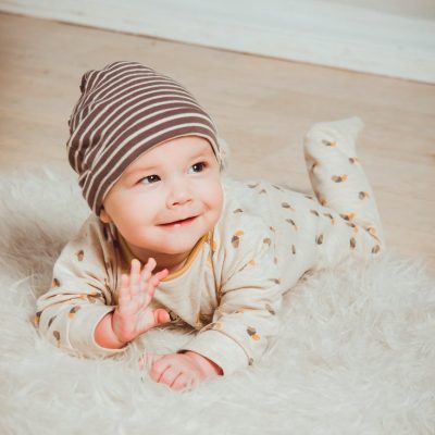 smiling baby lying on white mat